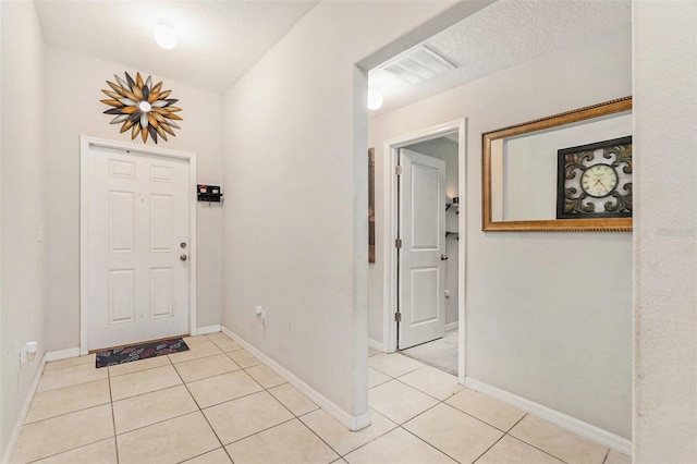 tiled entryway featuring a textured ceiling