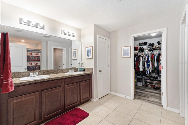 bathroom featuring a textured ceiling, vanity, and tile patterned flooring