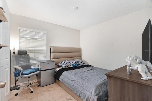 bedroom with light colored carpet and stainless steel refrigerator