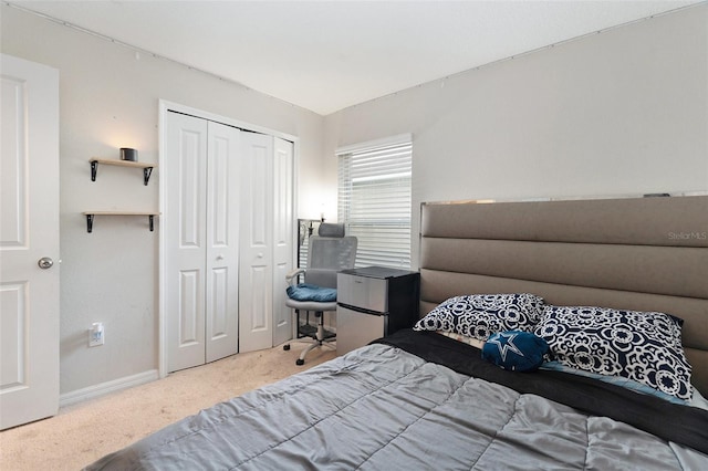 carpeted bedroom with a closet and stainless steel fridge