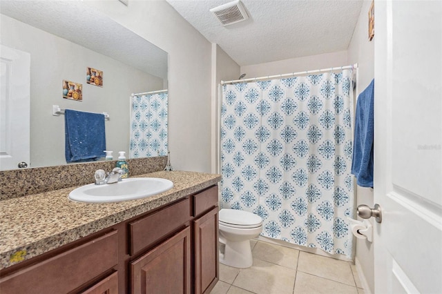 bathroom with toilet, vanity, tile patterned flooring, and a textured ceiling