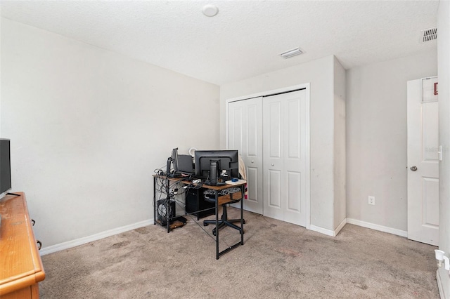 carpeted home office with a textured ceiling