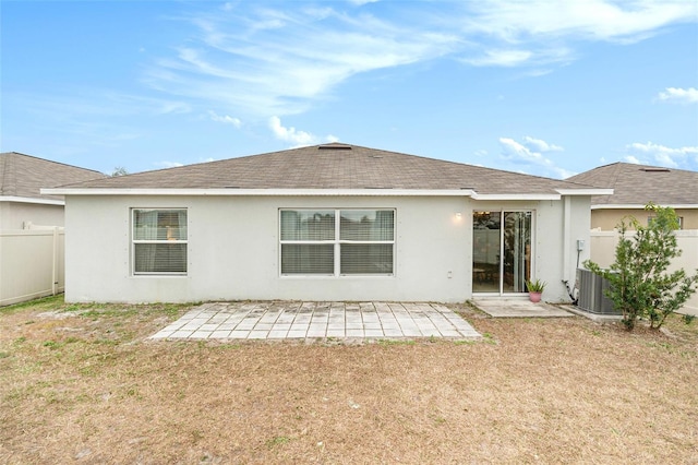 rear view of property featuring cooling unit, a patio area, and a yard