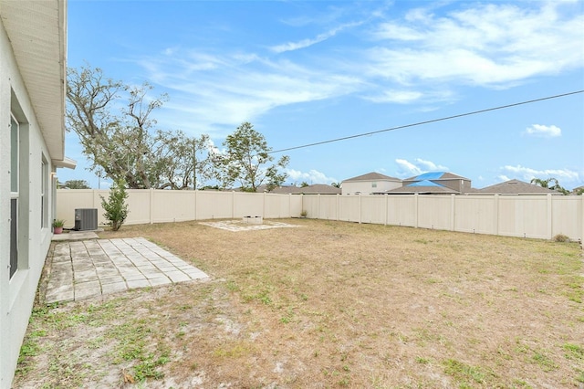 view of yard with central AC unit and a patio