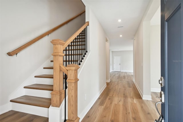 staircase with hardwood / wood-style floors