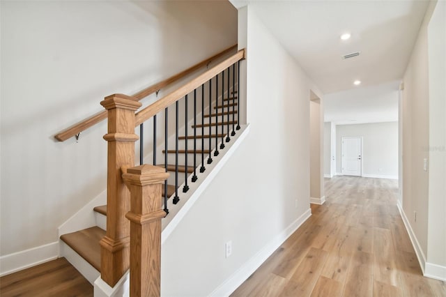 staircase with hardwood / wood-style floors