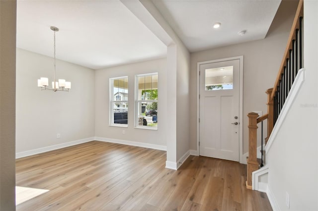 entrance foyer featuring an inviting chandelier and light hardwood / wood-style flooring