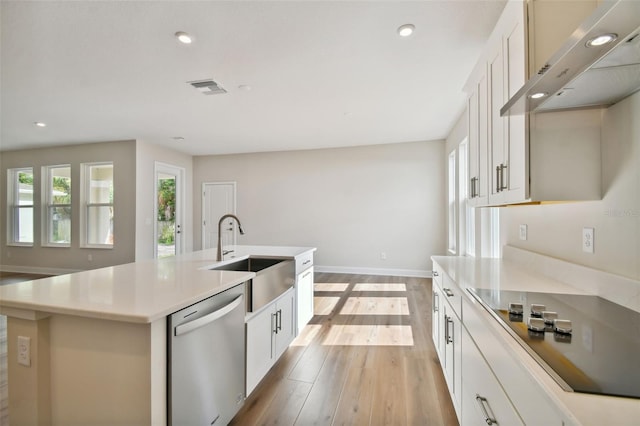 kitchen featuring sink, white cabinets, stainless steel dishwasher, and a kitchen island with sink