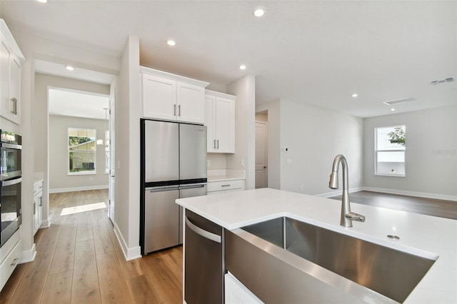 kitchen featuring white cabinets, plenty of natural light, sink, and stainless steel appliances