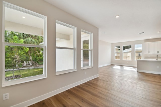 unfurnished living room with sink and light wood-type flooring