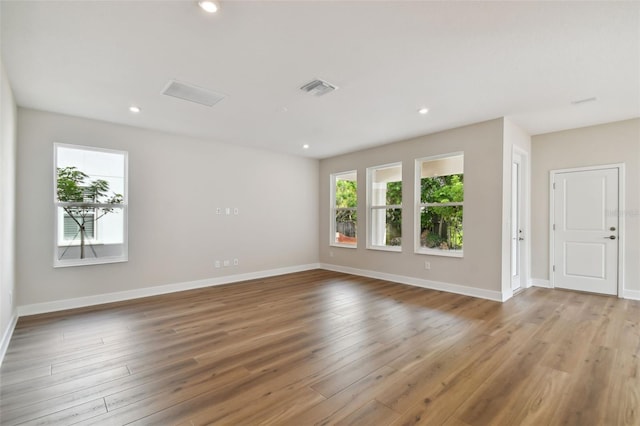 empty room featuring plenty of natural light and hardwood / wood-style flooring