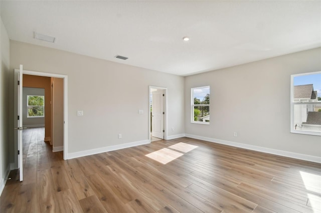 unfurnished room featuring light hardwood / wood-style floors and a healthy amount of sunlight