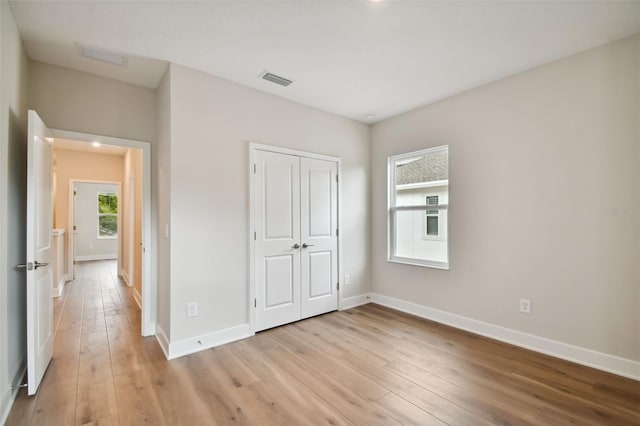 unfurnished bedroom featuring a closet and light hardwood / wood-style floors