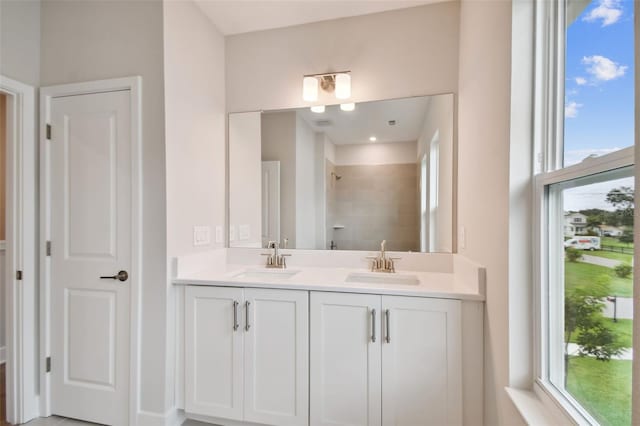 bathroom with tiled shower and vanity