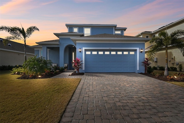 view of front of property featuring a garage and a lawn