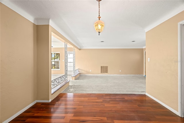 empty room featuring dark wood-type flooring and a textured ceiling