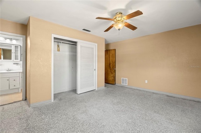 unfurnished bedroom with ceiling fan, sink, connected bathroom, and a closet