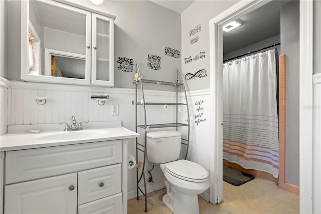 bathroom featuring toilet, vanity, and a shower with curtain