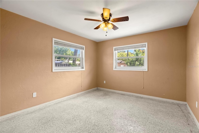 empty room with ceiling fan and plenty of natural light