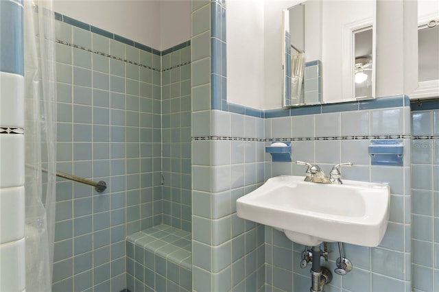 bathroom with sink, tile walls, decorative backsplash, and tiled shower