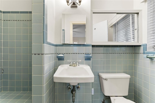 bathroom with toilet and tile walls