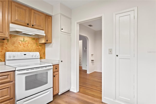 kitchen featuring decorative backsplash, light hardwood / wood-style floors, and electric range