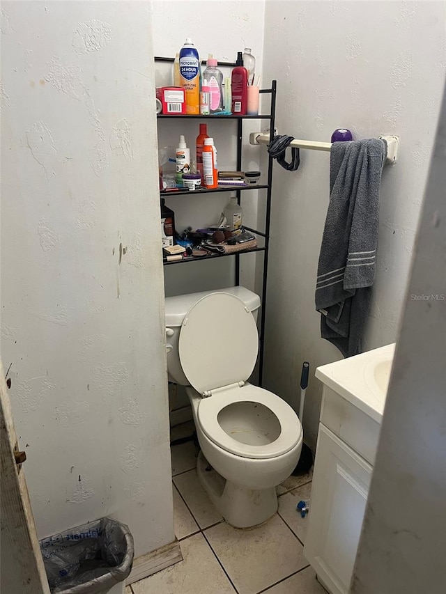 bathroom with toilet, vanity, and tile patterned flooring