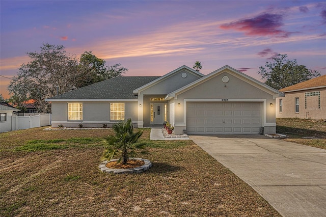 ranch-style house with a garage and a yard