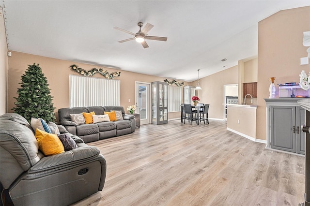 living room with sink, vaulted ceiling, ceiling fan, and light hardwood / wood-style floors