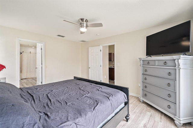 bedroom featuring light hardwood / wood-style floors, ensuite bathroom, and ceiling fan