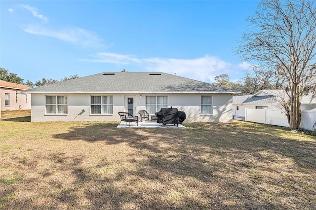 rear view of property with a patio and a lawn