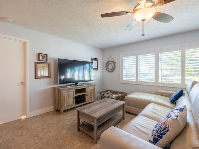 living room featuring ceiling fan and a textured ceiling