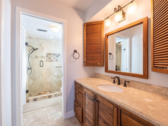 bathroom with tile patterned flooring, vanity, toilet, and a shower with shower door