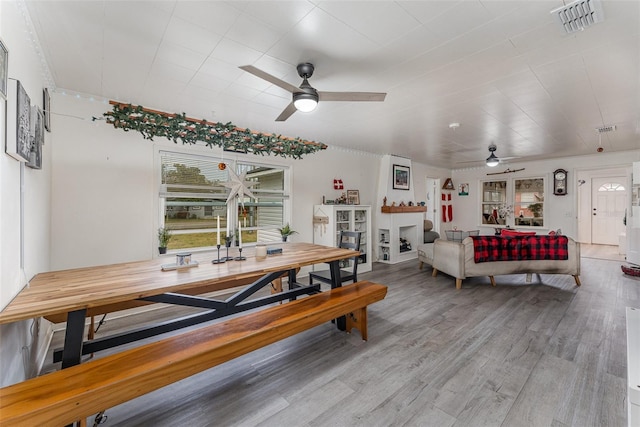 dining space with ceiling fan and light hardwood / wood-style flooring