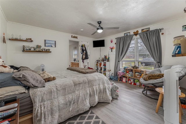 bedroom with ceiling fan, hardwood / wood-style floors, and ornamental molding