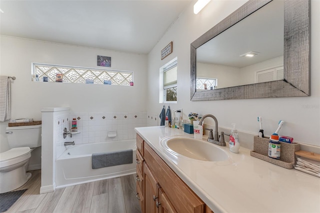 bathroom with hardwood / wood-style floors, a bathtub, vanity, and toilet