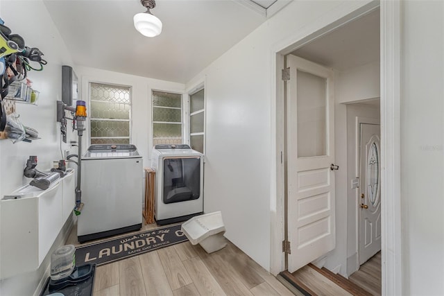 clothes washing area featuring light wood-type flooring and washing machine and clothes dryer