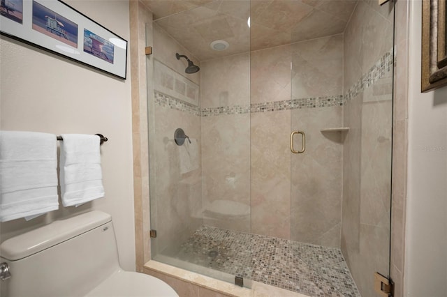 bathroom featuring toilet and a shower with door