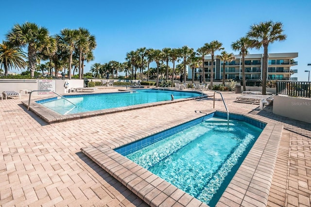 view of swimming pool with a patio area and a community hot tub