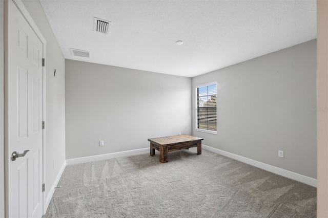 unfurnished bedroom featuring light carpet and a textured ceiling