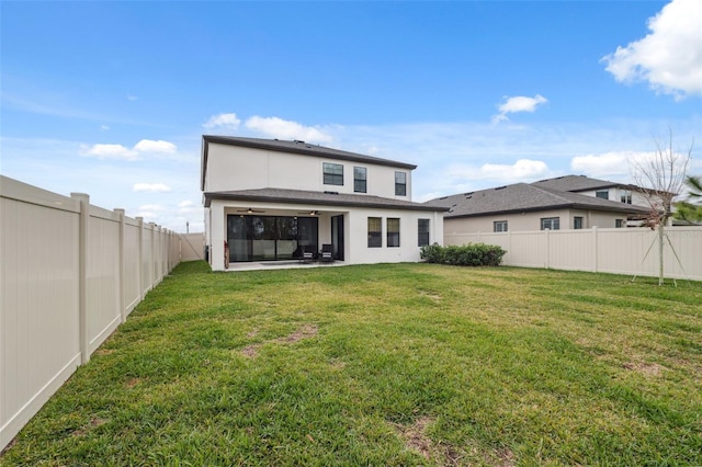 back of property featuring ceiling fan and a yard