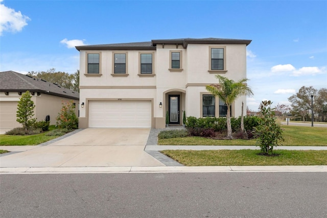 traditional home featuring an attached garage, driveway, a front yard, and stucco siding