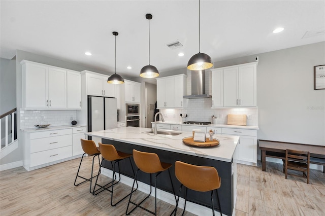 14786 Horse Trot Rd, Lithia, FL 33547 - kitchen with wall chimney exhaust hood, a sink, appliances with stainless steel finishes, tasteful backsplash, and light wood-style flooring