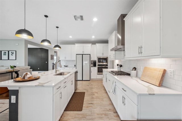 14786 Horse Trot Rd, Lithia, FL 33547 - kitchen with appliances with stainless steel finishes, a sink, wall chimney exhaust hood, white cabinetry, and decorative backsplash