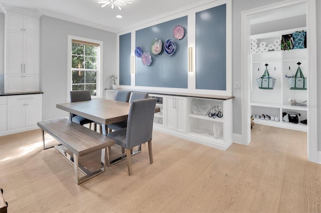 dining space with light wood-type flooring and ornamental molding