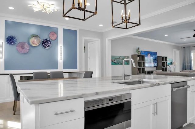 kitchen featuring sink, white cabinetry, crown molding, and hanging light fixtures