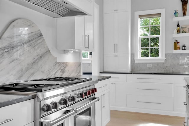 kitchen featuring white cabinetry, range with two ovens, and custom range hood