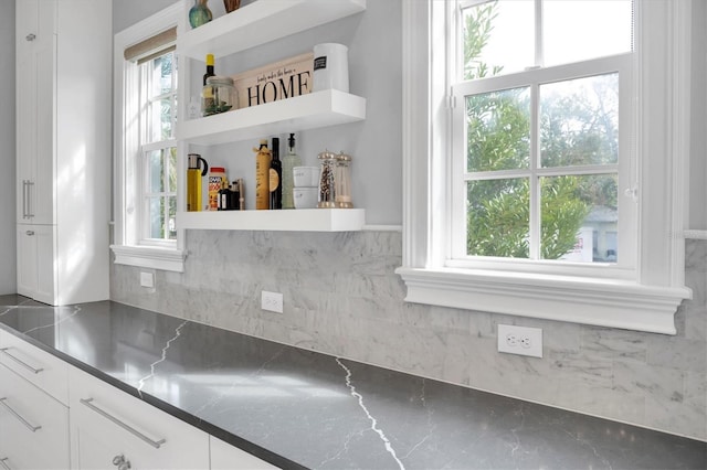 kitchen with stainless steel counters and white cabinetry