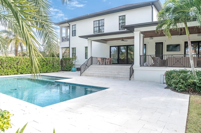 back of house featuring ceiling fan, a patio area, and a fenced in pool