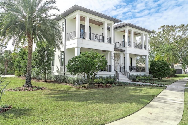 view of front facade featuring a balcony and a front yard